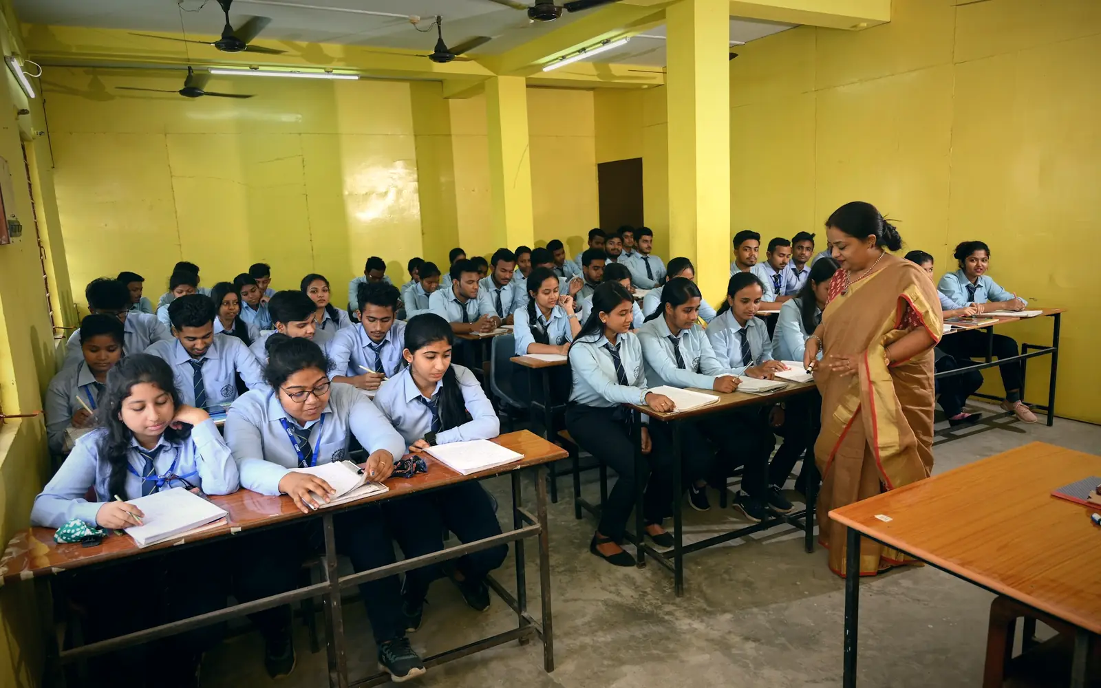 Teacher with students at their desks in an Indian classroom