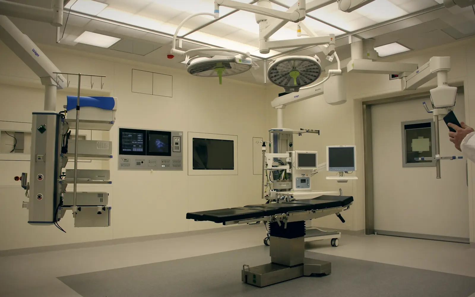 Hospital operating theatre with surgical lights, monitors and an operating table