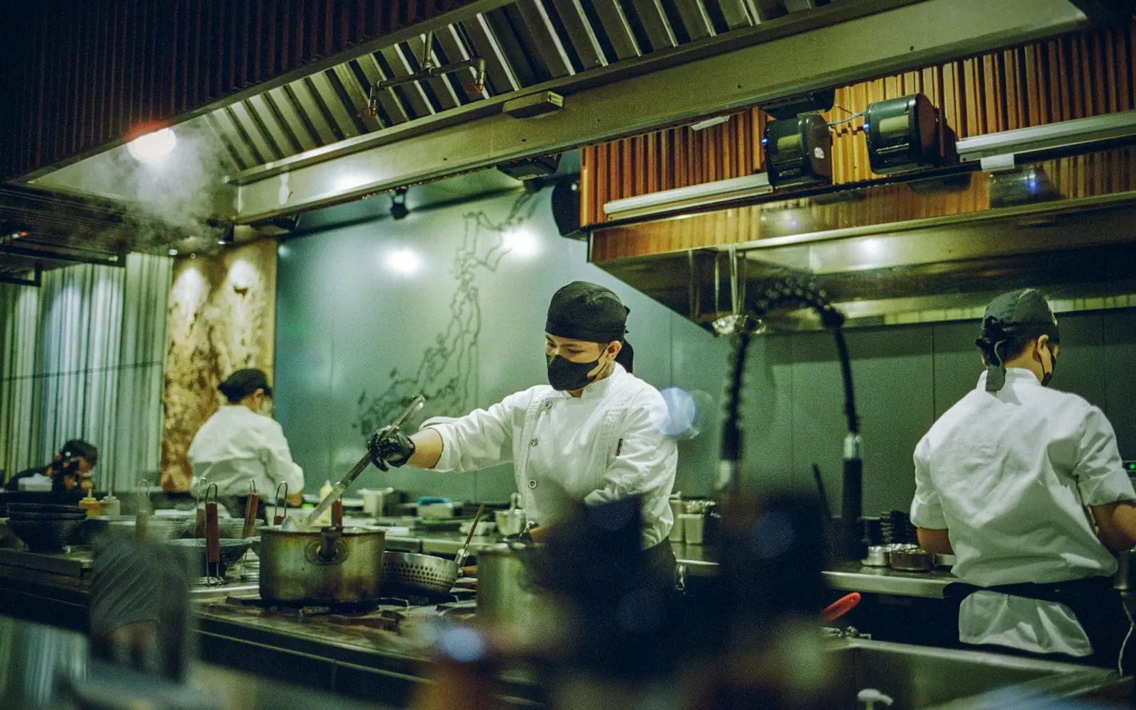 Chefs preparing food in a busy commercial kitchen