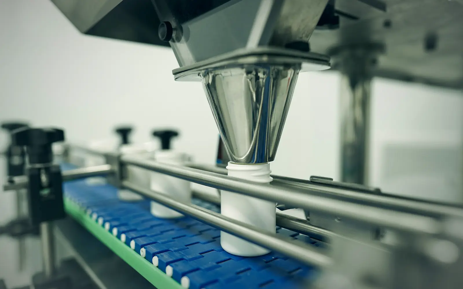 Bottles moving through an automated filling line in a pharmaceutical cleanroom