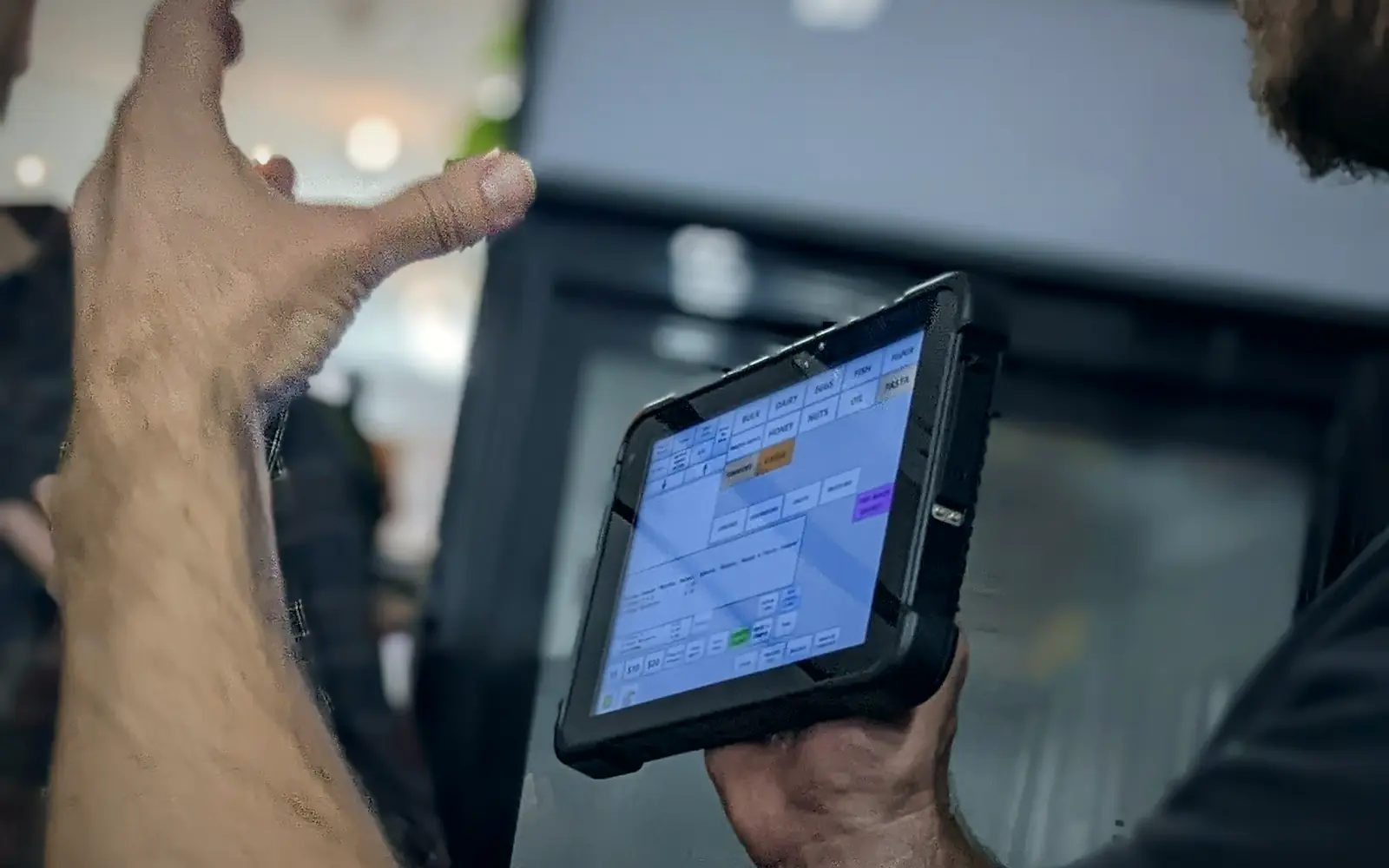 Professional holding a rugged tablet while recording equipment details