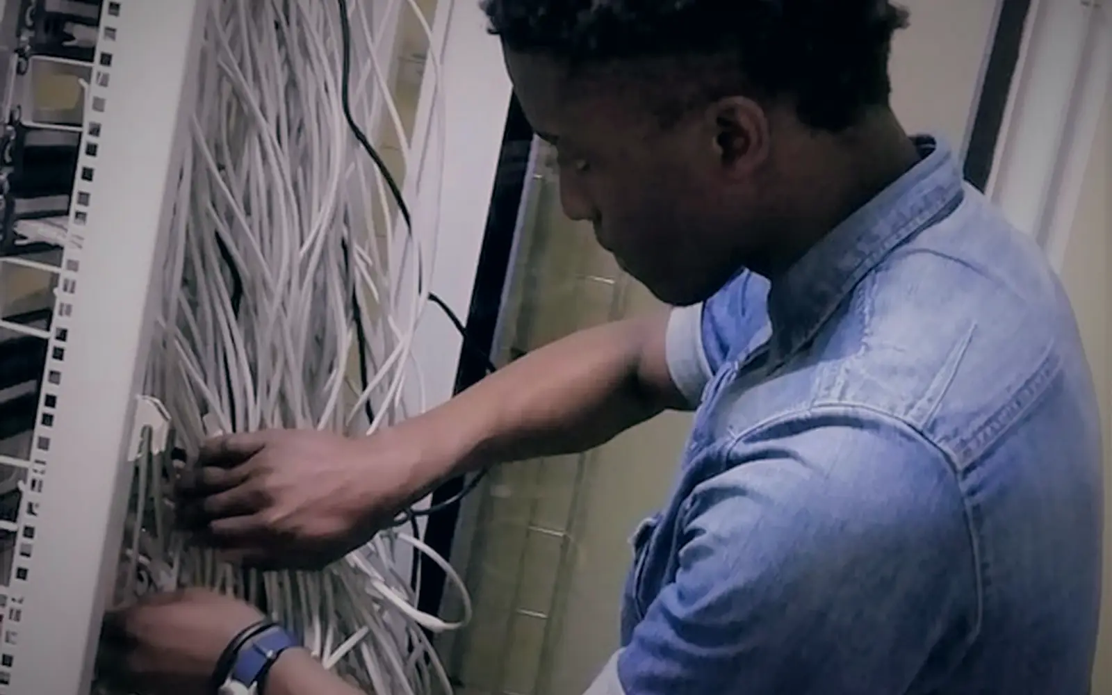 IT technician organising network cabling in a server cabinet