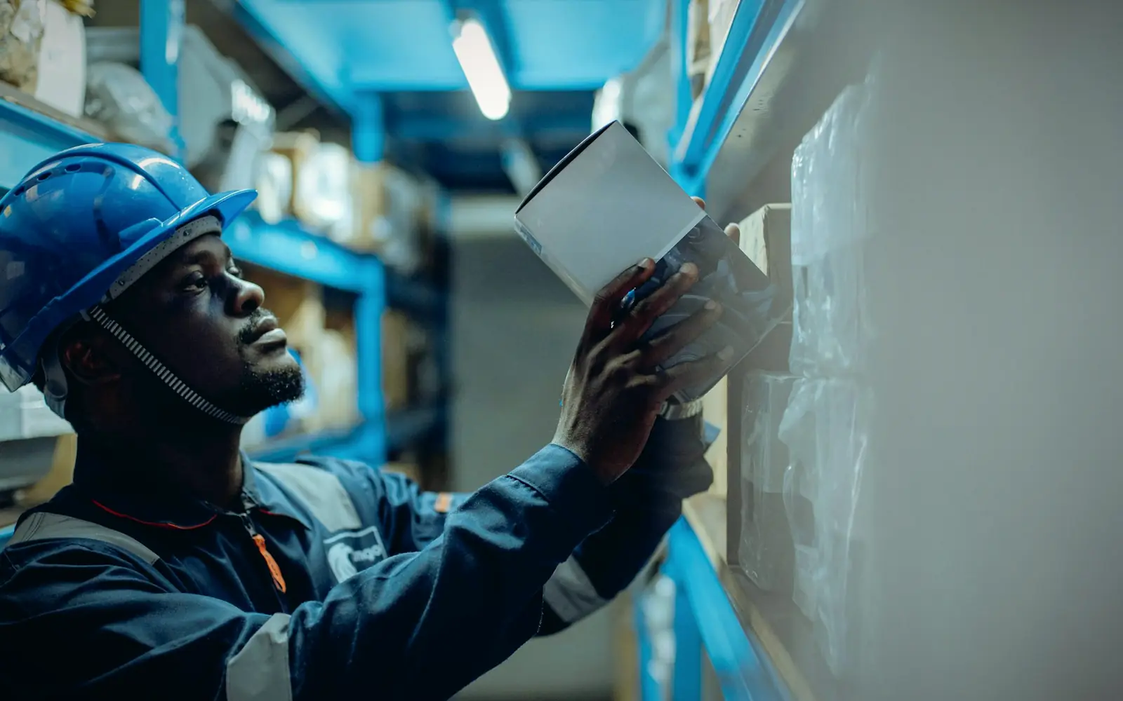 Engineer in a hard hat checking equipment in a facility