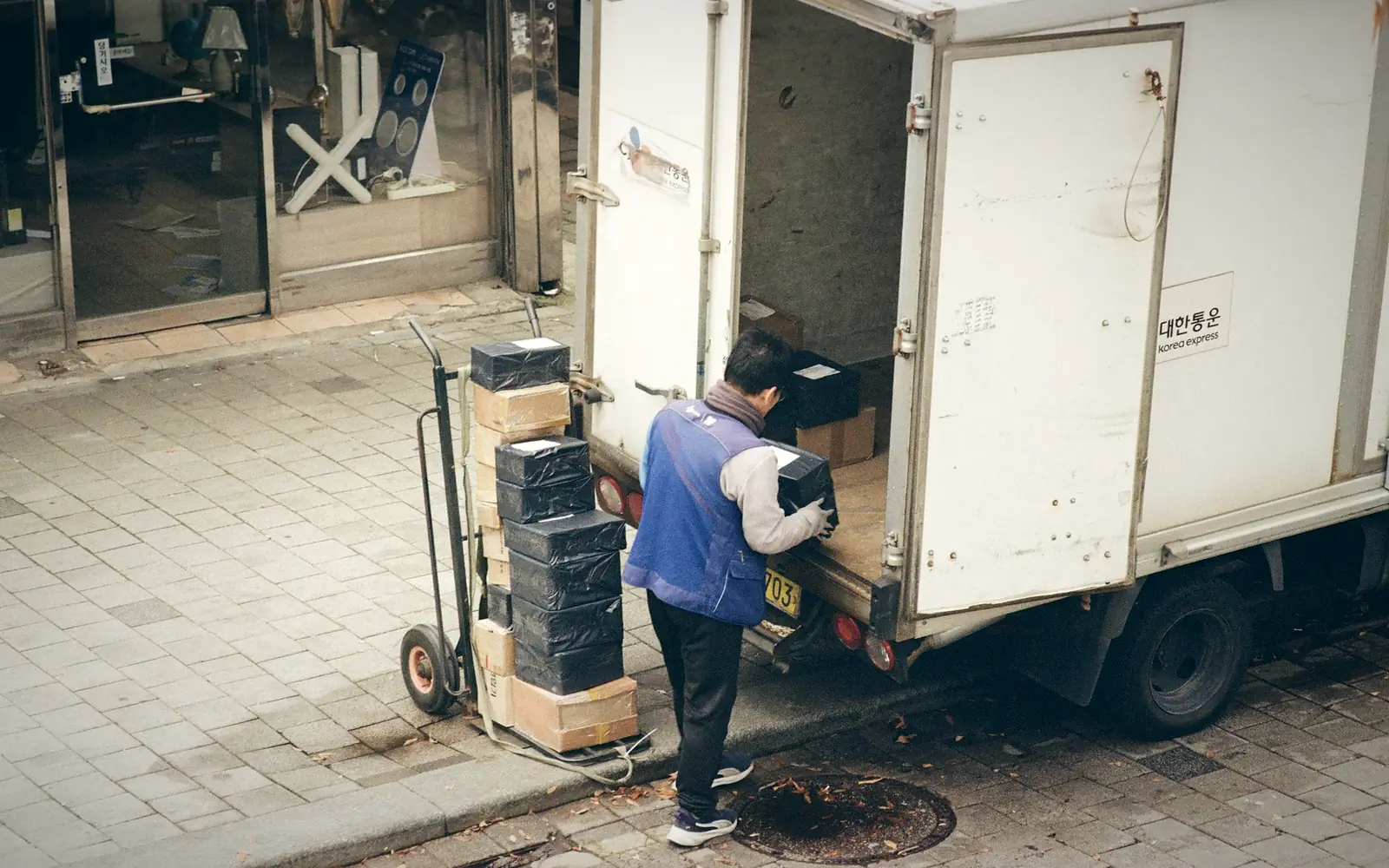 Delivery worker unloading boxes from a truck onto a hand trolley