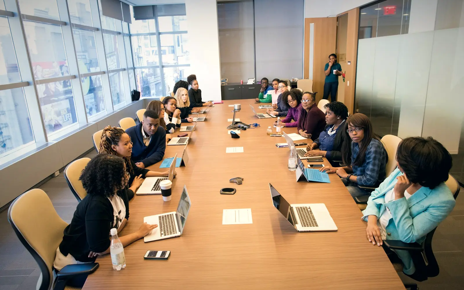 Team meeting with laptops around a long boardroom table